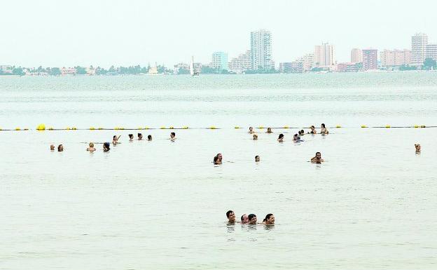 Bañistas en la playa de Mar de Cristal, en el Mar Menor, disfrutando de un chapuzón a media mañana de ayer. 