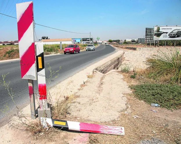 Dos postes reflectantes, repasados con pintura roja, 'advierten' de la presencia de una curva sin quitamiedos y del cauce de la rambla de Canteras.