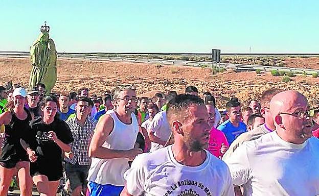 Los devotos corren con la imagen de la virgen de Manjavacas, envuelta para no sufrir daños, este pasado domingo. 