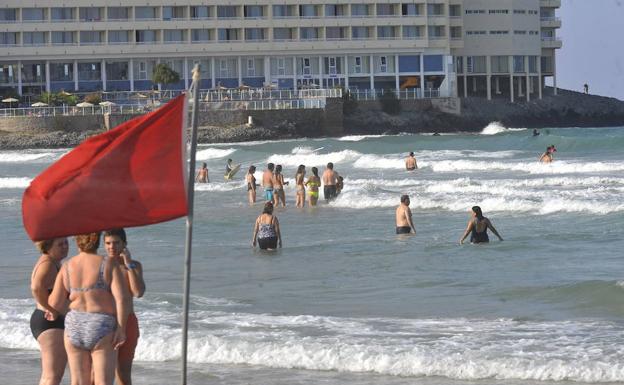 Numerosos bañistas, en el Galúa, hacen caso omiso a la bandera roja.