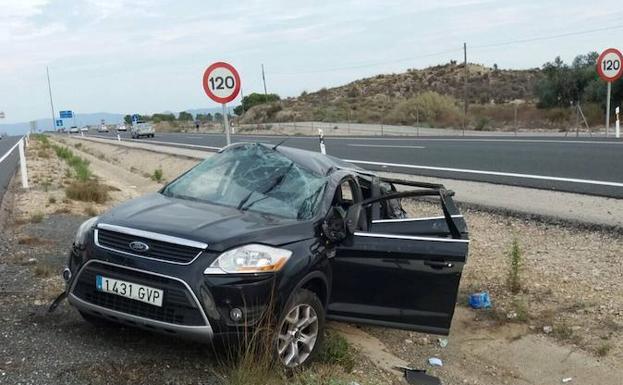 Uno de los vehículos accidentados en el arcén de la carretera.