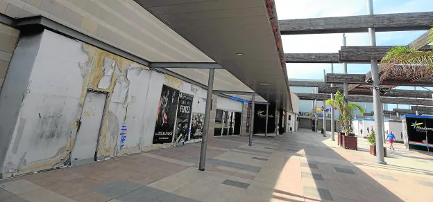 Locales cerrados y descuidados en la planta superior del centro comercial Mandarache, con los cines al fondo.