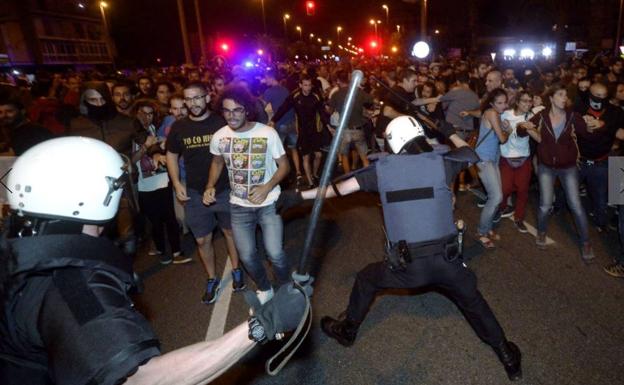 Un agente carga contra el grupo de manifestantes que se concentraron en Ronda Sur, donde se lanzaron piedras y botellas.