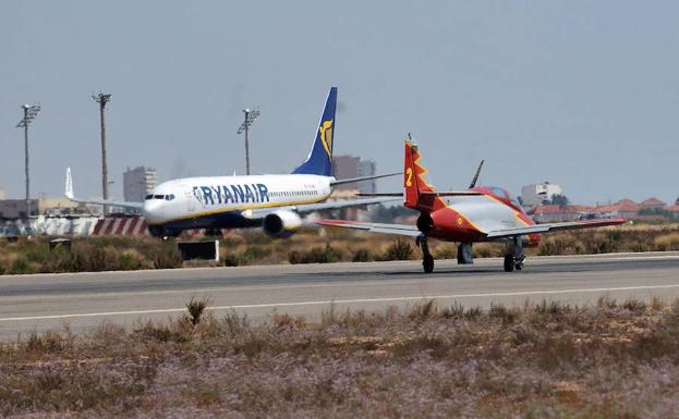 Un avión de Ryanair en San Javier mientras un reactor de la Academia maniobra en la pista.