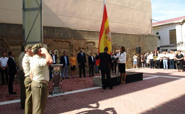 La alcaldesa de Archena, Patricia Fernández, iza una enseña de España.