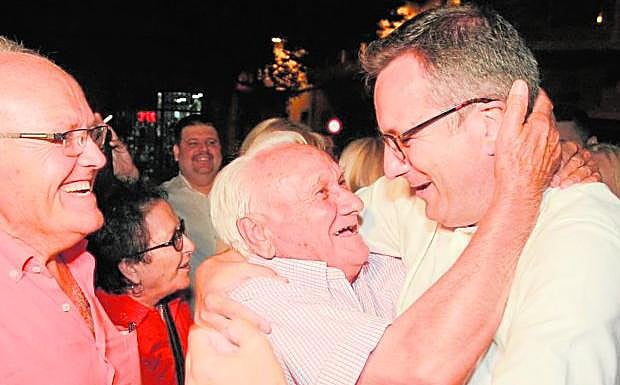 Diego Conesa recibe un efusivo abrazo de Manuel Gambín, presidente de la agrupación del PSOE de Alhama, tras conocerse su victoria en las primarias.