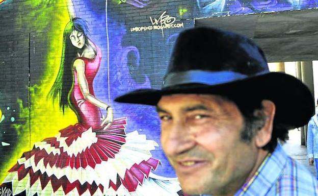 Flamenco en las calles. Ramón Santiago, con su amigo Miguel al fondo, delante de un mural en el que aparecen una bailaora y Paco de Lucía.