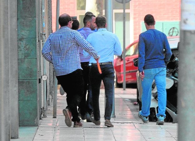 Los policías, abandonando ayer los juzgados por una puerta lateral. 