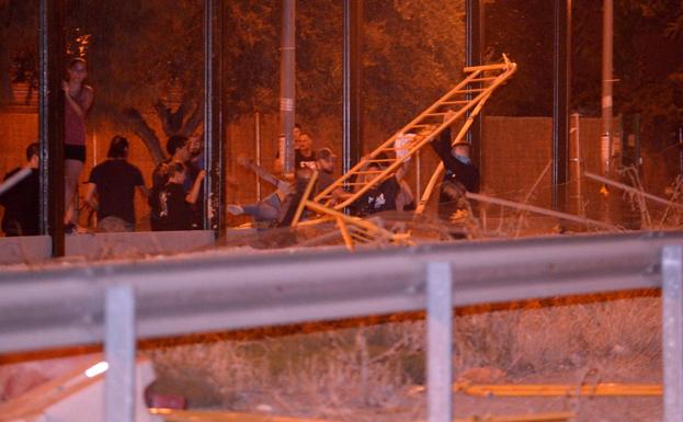 Un grupo de jóvenes desmontando pantallas y causando destrozos en las obras del AVE, este martes por la noche.