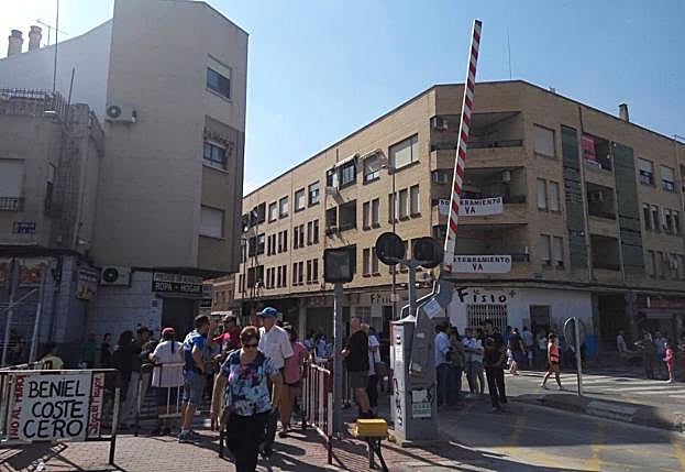 Vecinos de las vías, este domingo por la mañana, en el paso a nivel de Santiago el Mayor.