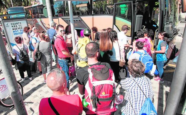 Los viajeros que se quedaron sin tren suben a uno de los autobuses fletados por Renfe.