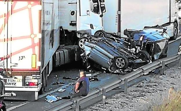 El camionero sentado en el quitamiedos tras el siniestro.