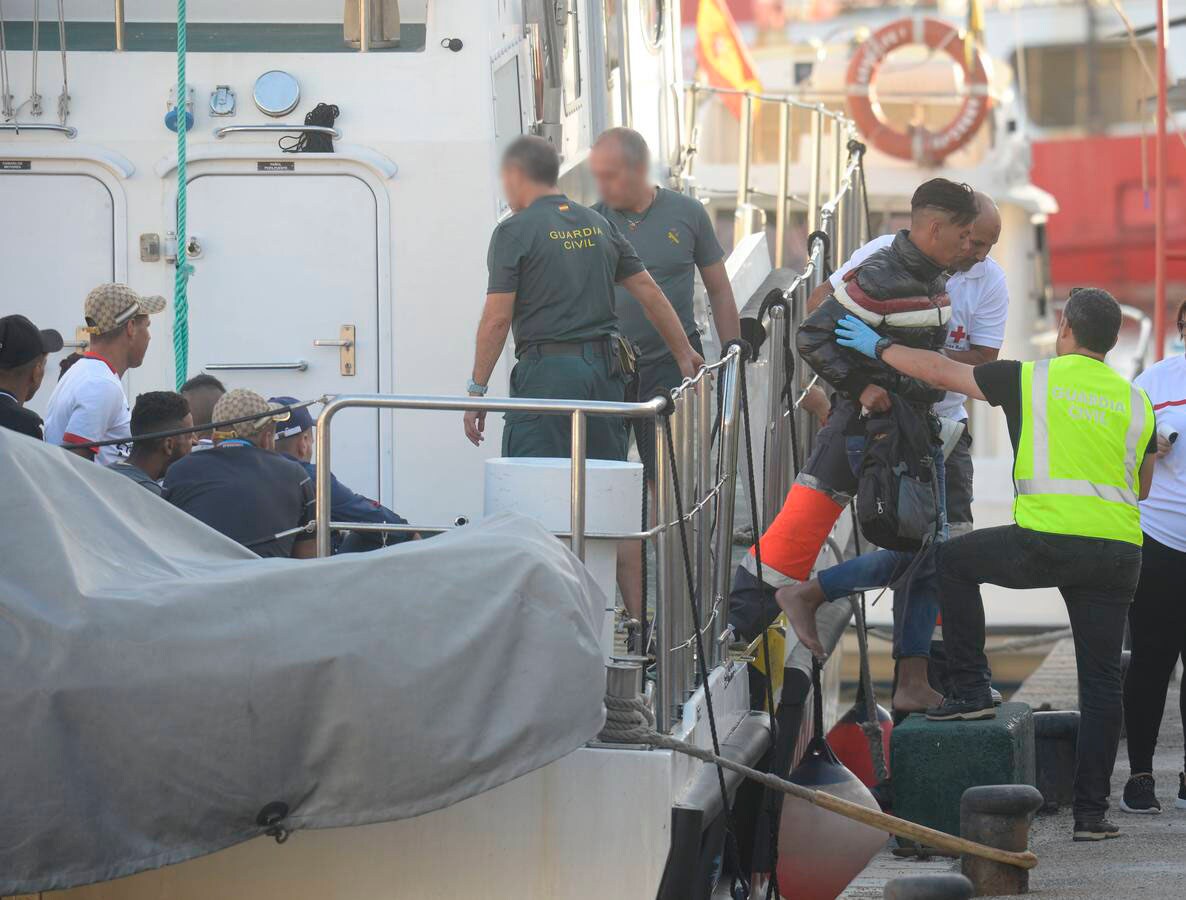 Agentes de la Guardia Civil y miembros de Cruz Roja ayudan a bajar de la patrullera a los inmigrantes rescatados este viernes..