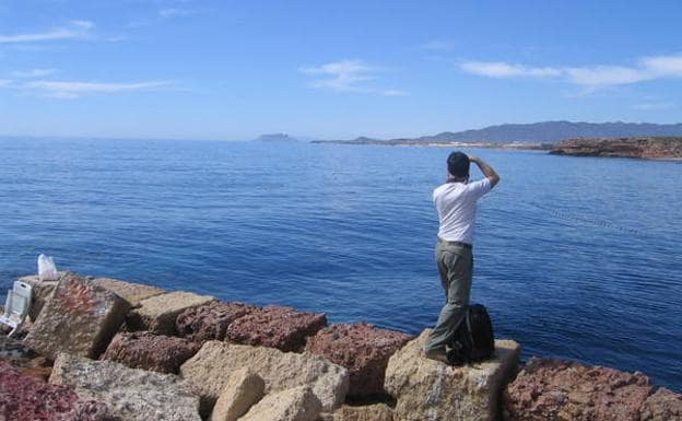 Un senderista toma una foto desde el embarcadero de la Cala de la Grúa. Al fondo se distingue el Lomo de Bas y Cabo Cope.