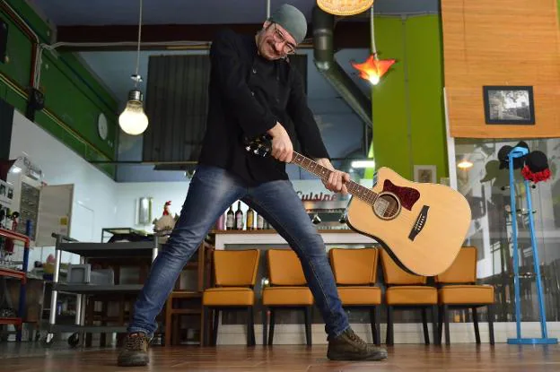 Alberto del Cerro agita una guitarra en su restaurante, El Pollo Rockero.