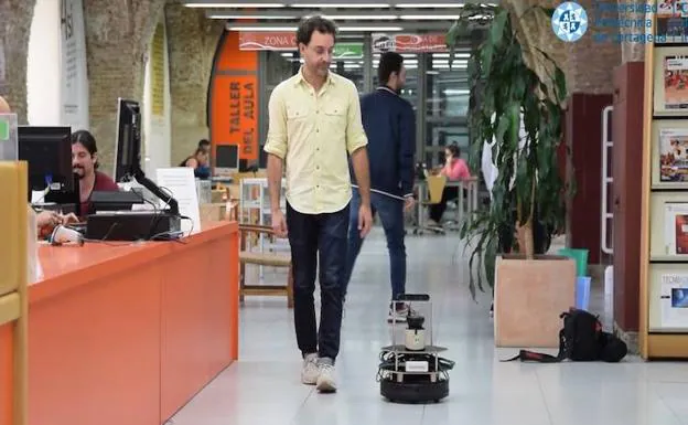 El robot acompaña a un usuario de la biblioteca. 