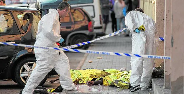 La Policía Científica toma muestras del doble crimen, con los cadáveres aún tendidos en el suelo.