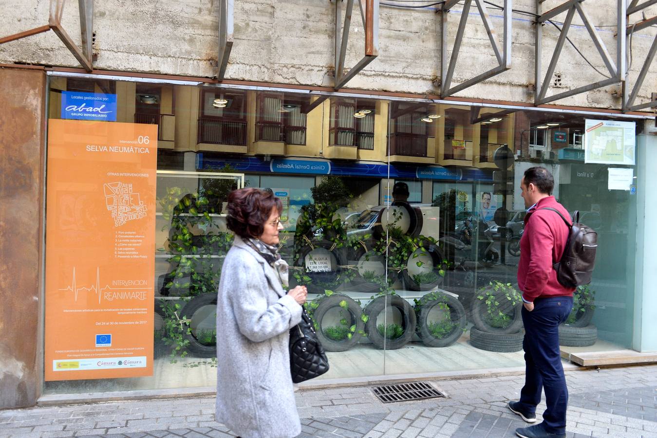 Un bodegón con muñecos dorados articulados, unas pajareras llenas de cascabeles o un montón de neumáticos decorados con plantas enredaderas son algunas de las propuestas de la arquitecta Helia San Nicolás que ha reconvertido los escaparates de siete comercios de la ciudad