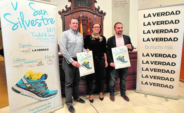 Juan Miguel Bayonas, Pilar Wals Rúa y Diego José Mateos con el cartel de la prueba. 