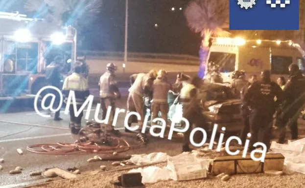 Los servicios de emergecnias atienden a los heridos en el turismo accidentado. 