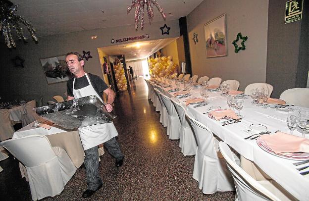 Un empleado de La Dama de Oro, ayer, con una bandeja, ultimando los preparativos en el salón.