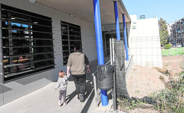 Un vecino entra con una niña a Pediatría de San Antón, el edificio junto al que se construirá la segunda fase del centro de salud.