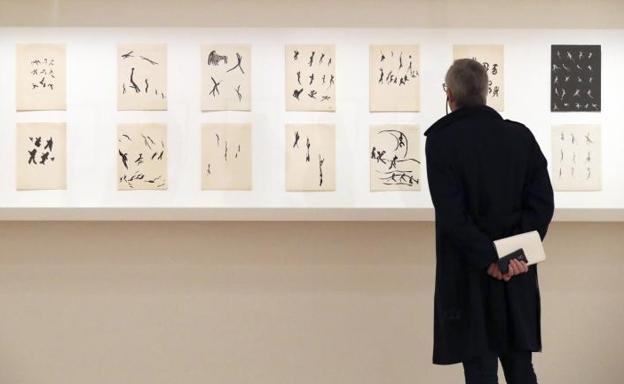 Un hombre observa diferentes dibujos que forman parte de la nueva exposición de Henri Michaux.