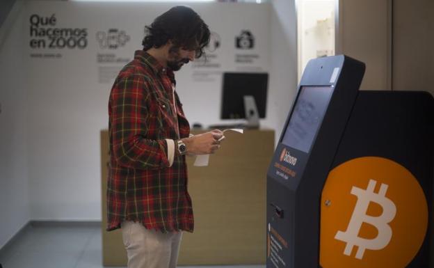 Imagen principal - Curro Quevedo cambia euros por bitcoins en el cajero instalado en la tienda Zooo de Madrid.