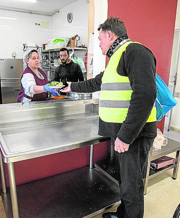 Un residente de la Hospitalidad coge una ensalada.