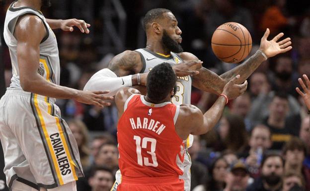 LeBron James disputa un balón con James Harden. 