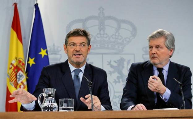 Rafael Catalá y el portavoz del Gobierno Íñigo Méndez de Vigo (d), durante la rueda de prensa que han ofrecido tras la reunión este viernes del Consejo de Ministros. 