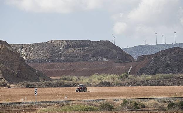 Imagen de archivo de un agricultor labrando con su tractor, a los pies de la corta Los Blancos I, en la que se acumulan desde el año 2005 los residuos procedentes de la balsa Jenny.