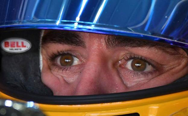 Fernando Alonso observa con la visera de su caso levantada. 