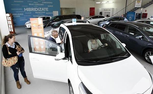 Una familia comprueba las prestaciones de un coche en un concesionario