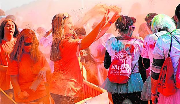 Una colaboradora de la organización 'atiza' con el naranja a los participantes.