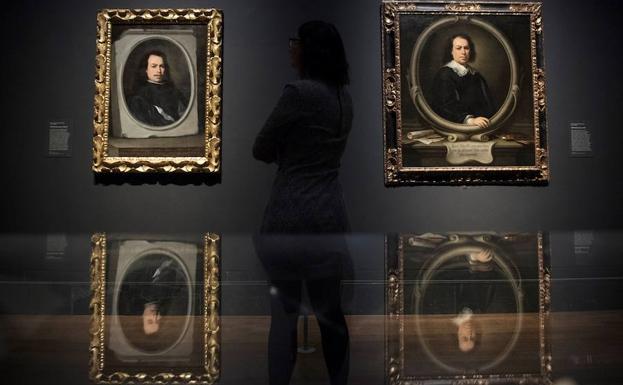 Una mujer observa dos autorretratos de Murillo. 