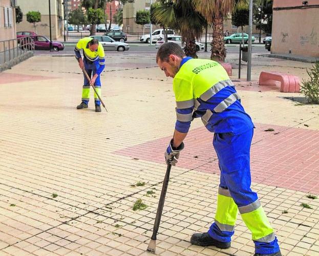 Dos trabajadores eliminan suciedad en el Ensanche.