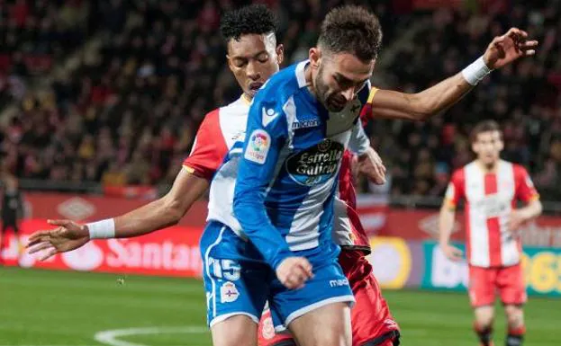 El delantero del Deportivo Adrián López pelea un balón con el defensa colombiano del Girona Johan Mojica.