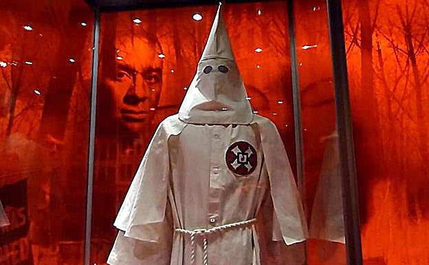 Imagen de un afroamericano detrás de la indumentaria de un miembro del Ku Klus Klan, una de las instalaciones que componen la exposición de National Geographic: 'Americano yo soy; la huella africana' . 