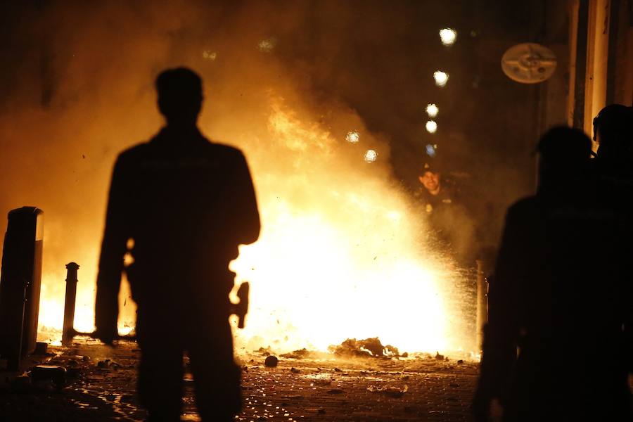 Un grupo de más de medio centenar de personas han quemado contenedores y causado desperfectos en el mobiliario urbano en el madrileño barrio de Lavapiés tras la muerte este jueves de un mantero de 35 años y origen subsahariano a causa de una parada cardiorrespiratoria.