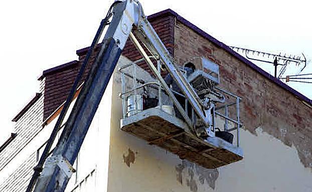 Un trabajador subido en un andamio.