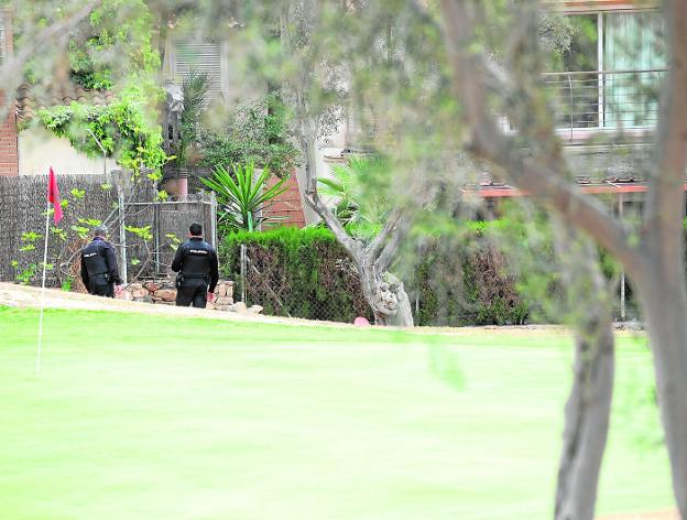 Dos agentes de la Policía Nacional rastrean, ayer, el campo de golf de Altorreal, muy cercano a una de las casas asaltadas.