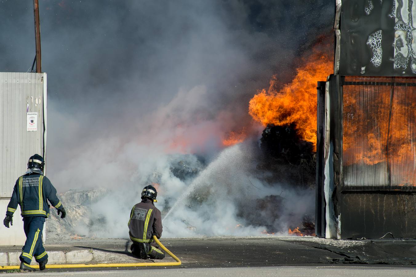 Los bomberos trabajan en la extinción de un incendio en una empresa de reciclaje de residuos en Santomera que ha originado una gran columna de humo a primera hora de la tarde, alrededor de las 16.30 horas de este miércoles.