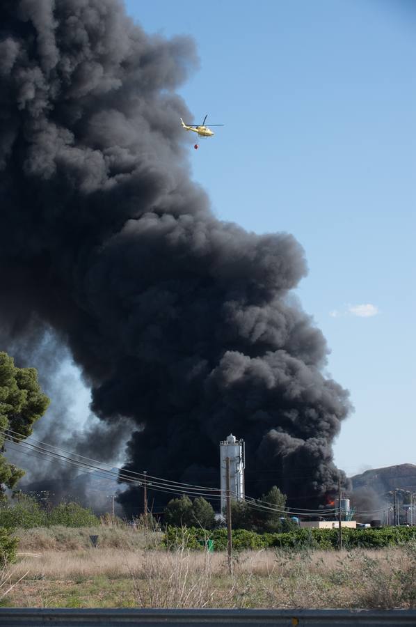 Los bomberos trabajan en la extinción de un incendio en una empresa de reciclaje de residuos en Santomera que ha originado una gran columna de humo a primera hora de la tarde, alrededor de las 16.30 horas de este miércoles.