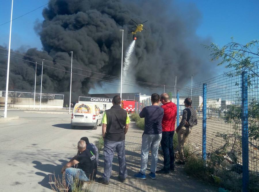 Los bomberos trabajan en la extinción de un incendio en una empresa de reciclaje de residuos en Santomera que ha originado una gran columna de humo a primera hora de la tarde, alrededor de las 16.30 horas de este miércoles.