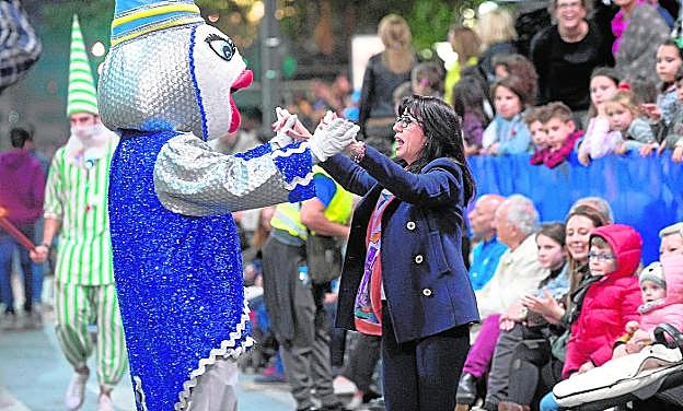 La mascota del Entierro, anoche, baila de alegría con una espectadora por la Gran Vía, ante la mirada atónita de los más pequeños.