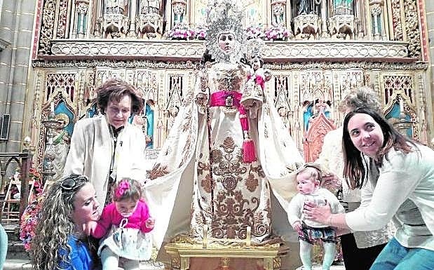 Dos jóvenes acercan a unos pequeños al sagrado manto de la Fuensanta.