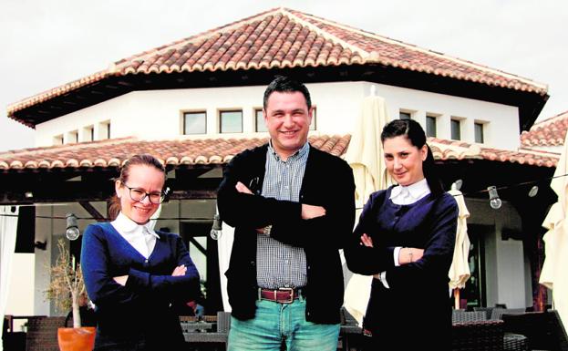 Julián Rodríguez, acompañado de Ivana y Cristina (d), dos de las camareras del Sándalo, en la terraza del restaurante ubicado en la Casa Club del campo El Valle.