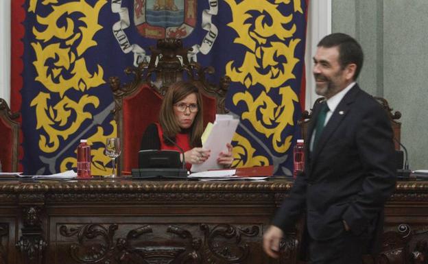 Castejón observa con gesto serio el paso de López, sonriente, en el transcurso de una sesión plenaria. 