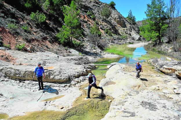 Tres senderistas cruzan las juntas de los arroyos Tercero y Blanco, junto al Torcal de Bojadillas, para seguir remontando el curso del Blanco.